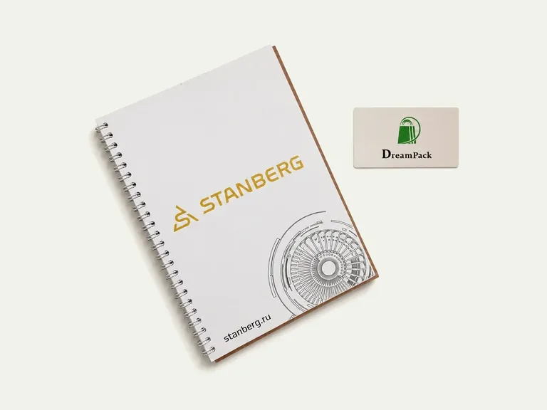 STANBERG — белый блокнот на пружине с золотистым логотипом и технической графикой.
