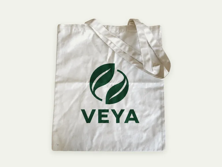 Белый текстильный шоппер «Вея» с длинными ручками и лаконичной зелёной одноцветной печатью.